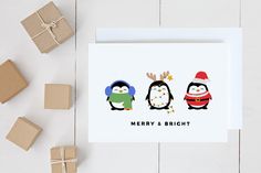 three penguins with christmas hats and antlers on their heads are standing next to presents