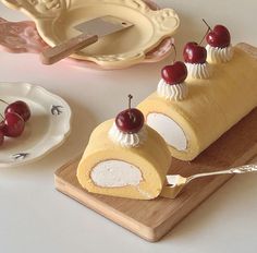 a piece of cake with cherries on top sitting on a cutting board next to a plate