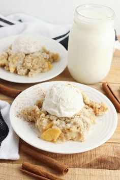 two white plates topped with dessert next to a jar of milk and cinnamon sticks on a wooden table