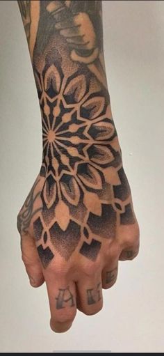 a person's hand with tattoos on it