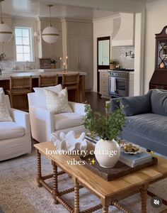 a living room filled with furniture and a kitchen in the backgroung area