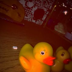 three rubber ducks sitting on top of a wooden table