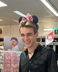 a young man wearing minnie mouse ears and a black shirt