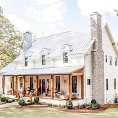 a large white house sitting on top of a lush green field