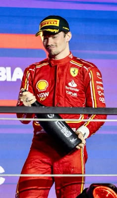 a man in red racing suit holding a water bottle