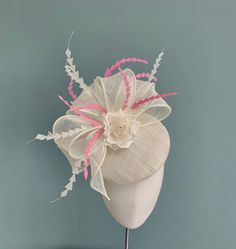 A beautiful ivory pillbox fascinator, with feathers and floral detailing. The perfect choice for Ascot, Kentucky Derby or a wedding. Made in ivory straw sinamay, this elegant fascinator features  a large double bow in ivory sinamay straw, and a delicate handmade silk dupion and organza multi petal rose that sits within the bow. The tail of the bow is slightly longer on one side, and twists gently down the side of the hat.  Scattered throughout the headpiece are chevron shaped coque feathers in i White Headpieces As A Spring Gift, White Headpieces For Spring Gift, White Fascinator For Kentucky Derby Gift, White Mini Hats For Royal Ascot, White Headpieces For Summer Gifts, White Summer Headpieces As Gifts, White Summer Headpieces For Gifts, White Mini Hat For Kentucky Derby Ceremony, White Summer Headpiece Gift