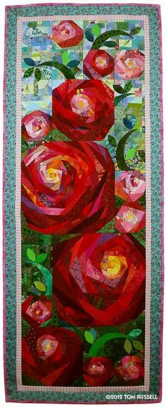 a quilted wall hanging with red roses on it