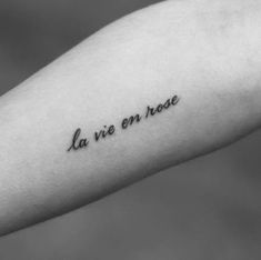 a person's arm with the words la vie en rose written on it in cursive font