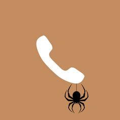 a phone with a spider hanging from it's side on a brown background,