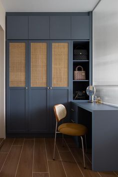 a chair sitting in front of a blue cabinet next to a desk and shelves with baskets on it