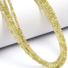 a strand of yellow glass beads on a white surface