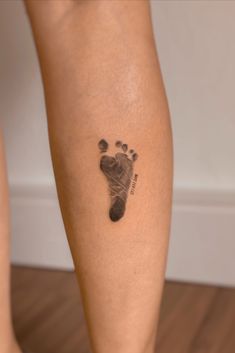 a woman's foot with a small hand and foot print on the side of her leg