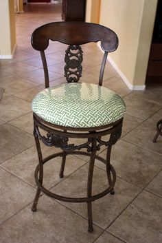 a wooden chair with a green patterned seat