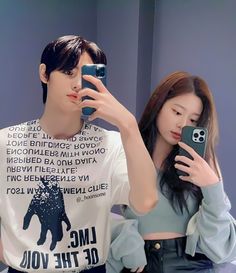 a man and woman taking a selfie in front of a mirror with their cell phones