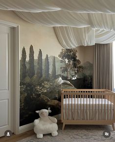 a baby's room with a large painting on the wall and a teddy bear