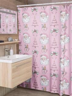 a pink shower curtain with santa claus and christmas trees on it, in front of a bathroom sink