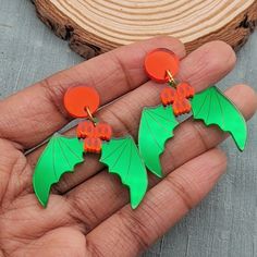 These Christmas Holly Earrings Are a Bit Spooky. They are reimagined with green bat wing leaves and red ghost berries. These come with a red circular stud. You may alternatively select fishhooks, huggie/leverbacks, or clip-ons and the circle will be replaced. Metal is silver-toned, if you would like gold-toned metal, add it to the special instructions in your cart! Dimensions: Dangle Earrings: 1.2 in (31 mm) L x 1.5 in (37 mm) W The drop length is about 2.0 in (51 mm). Materials: Mirror Acrylic Green Novelty Earrings For Halloween, Green Earrings For Halloween Gift, Green Novelty Jewelry For Halloween, Themed Red Earrings, Fun Red Jewelry For Halloween, Green Halloween Party Earrings, Fun Red Halloween Jewelry, Red Fun Halloween Jewelry, Handmade Green Halloween Earrings