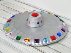 a paper plate that has some kind of hat on it with colored stones in the middle