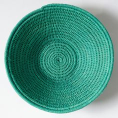 a green basket sitting on top of a white table