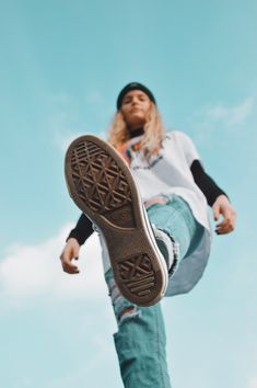 a skateboarder doing a trick in the air with his board and shoes on