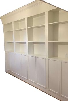 an empty white bookcase with no doors on the front and back shelves above it