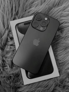 an apple iphone 11 pro sitting on top of a white box next to a gray furry surface