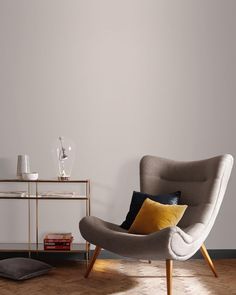 a living room with a chair, side table and lamp on the floor next to it