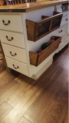 a kitchen island with drawers on it and wooden flooring in front of the island