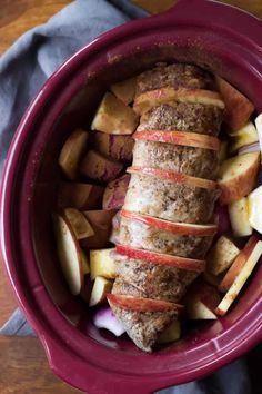 a red bowl filled with sliced apples and meat