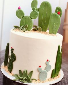 a cake decorated with cactus and succulents on a table