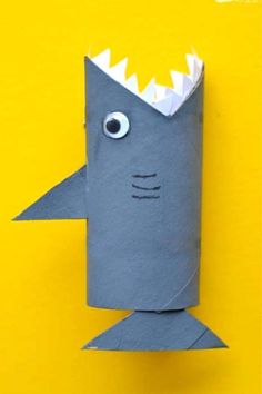 a shark made out of toilet paper on a yellow background