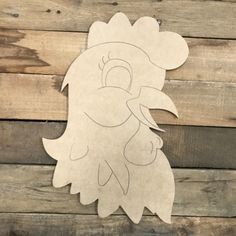 a paper cut out of a chicken on wooden planks