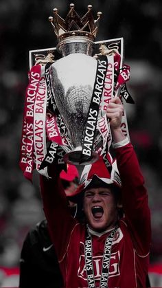 a man is holding up a trophy in the air with his face covered by ribbons