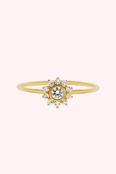 This 14kt gold diamond sunflower ring is a sparkly, feminine way to wear diamonds by incorporating your favorite floral. This stackable engagement ring pairs well with many of our dainty diamonds arcs.

This dainty sunflower ring stacks with the 14kt Solid Gold Diamond Arc Ring to complete the look! We also offer this stunning sunflower ring with a teal-colored sapphire center. Dainty 14k Gold Cluster Ring With Halo Setting, Dainty Diamond Ring With Halo Design, Dainty Diamond Ring With Halo, Dainty Yellow Gold Halo Diamond Ring, Yellow Gold Diamond Flower Ring With Center Stone, Dainty Yellow Gold Diamond Cluster Ring, Delicate 14k Gold Diamond Ring With Halo Setting, Delicate Yellow Gold Diamond Ring With Halo Setting, Yellow Gold Diamond Stackable Rings With Halo Setting