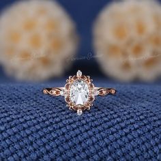 a close up view of a ring with an oval cut diamond in the center on a blue cloth