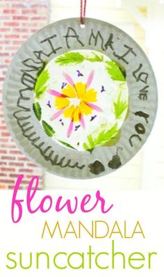 a paper plate suncather hanging from a string with the words flower on it