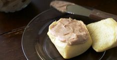 a piece of bread with peanut butter on it sitting on a plate next to a knife