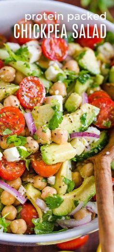 chickpea salad with tomatoes, cucumber and onions in a white bowl