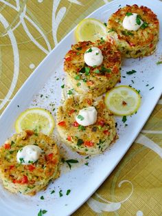 three crab cakes on a white plate with lemon slices