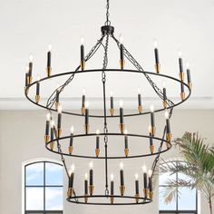 a large chandelier with many lights hanging from the ceiling in a living room