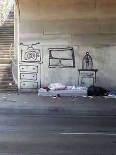 a painting on the side of a building with a tv and bed next to it