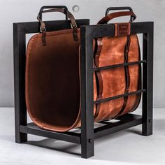 two brown bags sitting on top of a black stand