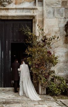 a bride and groom standing in front of a black door