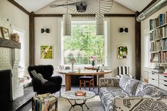 a living room filled with furniture and a fire place in front of a large window