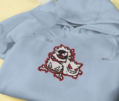 Introducing our Ghost Gengar Embroidered Hoodie, the perfect addition to your Pokémon collection. This sweatshirt features a meticulously crafted embroidered Gengar design, showcasing its mischievous nature. Made from premium quality materials, it ensures utmost comfort and durability. Whether you’re a die-hard Pokémon fan or looking for a unique gift, this hoodie is bound to impress. Embrace the dark side with style and make a statement wherever you go. Elevate your fashion game with our Hooded Hoodie With Machine Embroidery For Streetwear, Long Sleeve Hoodie With Machine Embroidery For Streetwear, Casual Hoodie With Machine Embroidery For Streetwear, Long Sleeve Hoodie With Embroidery For Streetwear, Casual Embroidered Hoodie For Streetwear, Hooded Sweatshirt With Machine Embroidery For Streetwear, Casual Hooded Hoodie With Machine Embroidery, Cotton Hoodie With Machine Embroidery, White Hooded Hoodie With Embroidered Patch