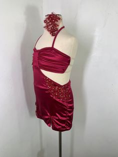 a mannequin wearing a red dress with beadings on it's neck