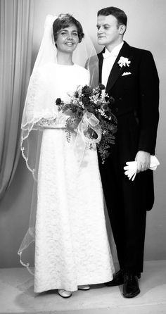 a bride and groom pose for a photo in their wedding day attire, dressed in black and white