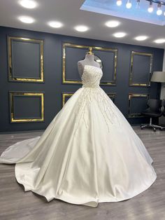 a white wedding dress on display in a room