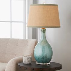 a table with a lamp on it next to a couch