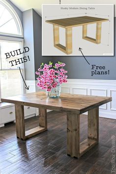 a wooden table sitting on top of a hard wood floor next to a vase with flowers